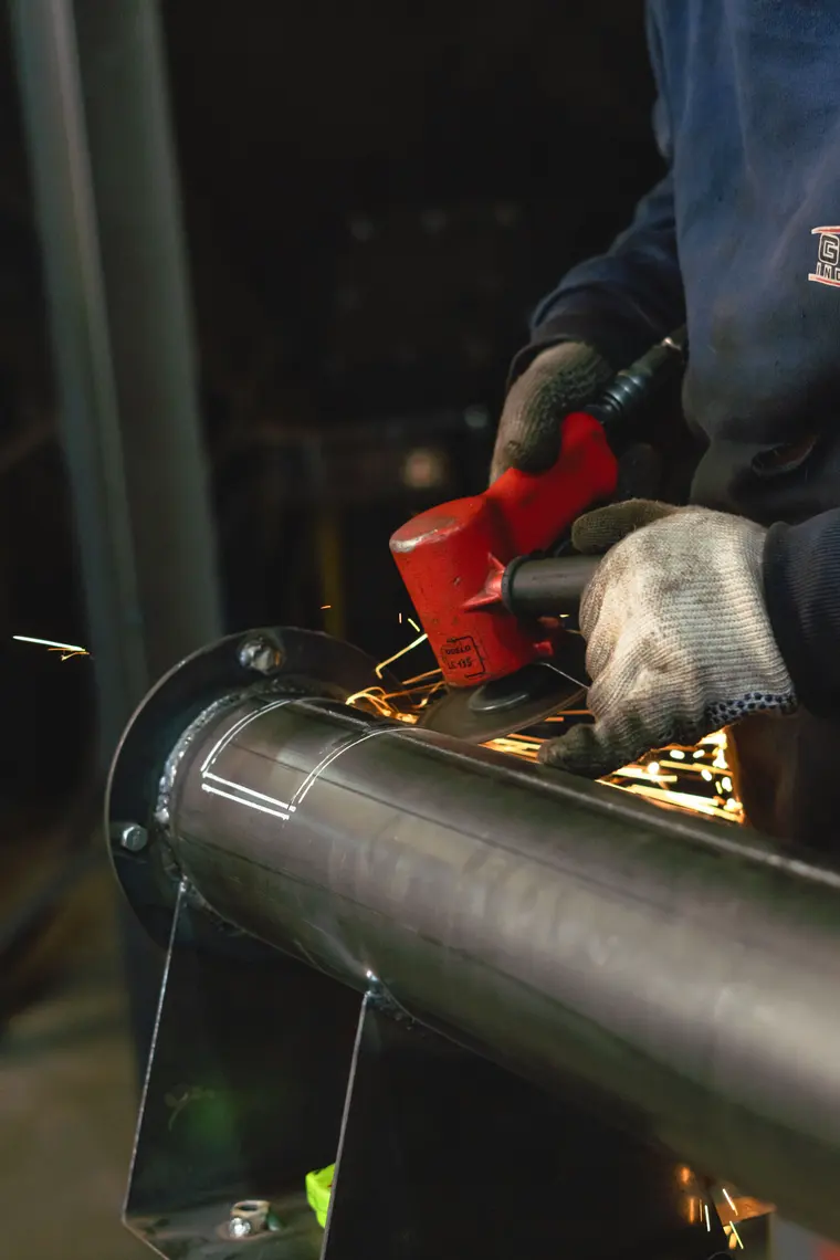 Grinding an auger tube, sparks flying